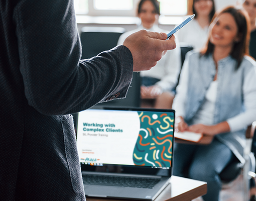 Person presenting to group of people with a screen that reads Working with Complex Clients